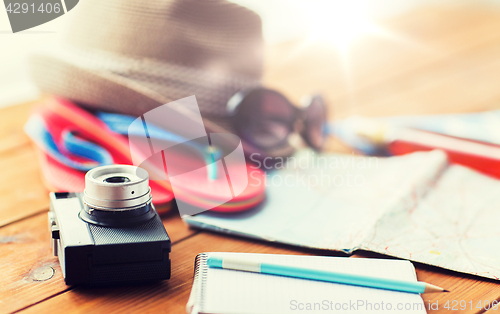 Image of close up of camera, notepad and travel stuff