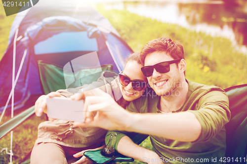 Image of couple of travelers taking selfie by smartphone