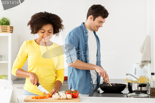 Image of happy couple cooking food at home kitchen