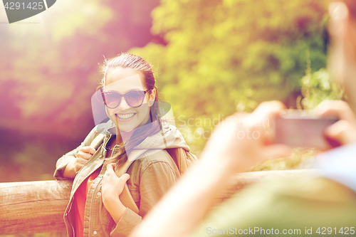 Image of couple with backpacks taking picture by smartphone