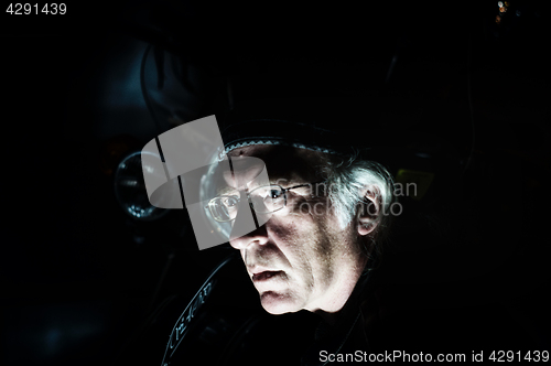 Image of man in front of motorcycle lit from below