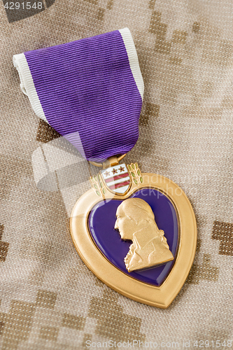 Image of Purple Heart Medal Laying on Military Fatigues