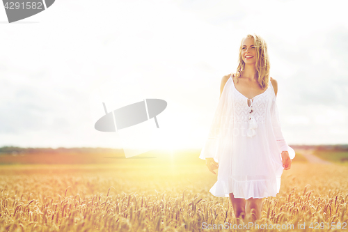 Image of smiling young woman in white dress on cereal field