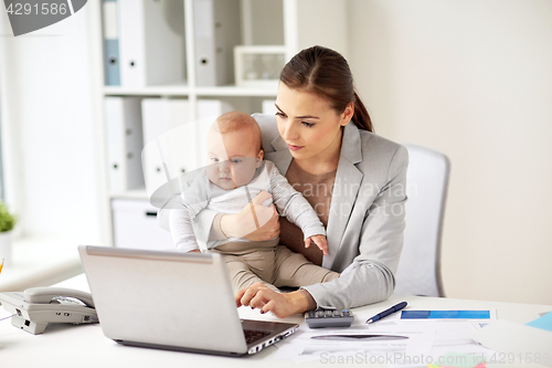 Image of happy businesswoman with baby and laptop at office