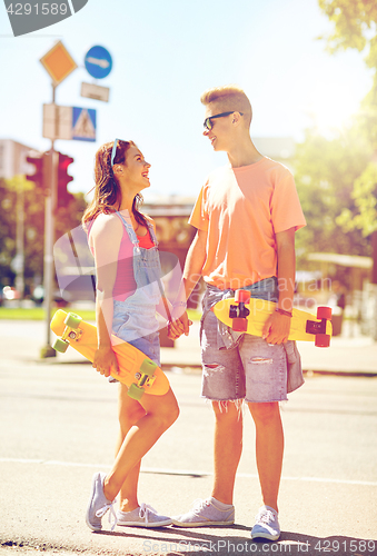 Image of teenage couple with skateboards on city street