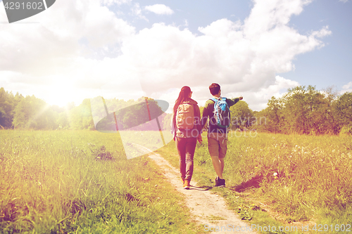 Image of happy couple with backpacks hiking outdoors
