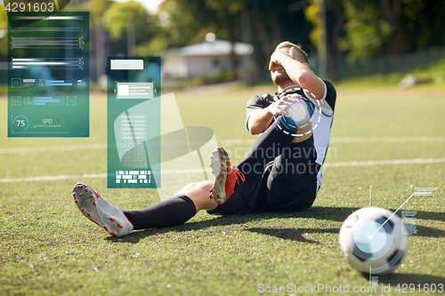 Image of injured soccer player with ball on football field