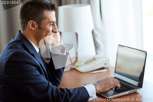 Image of businessman with laptop and smartphone at hotel
