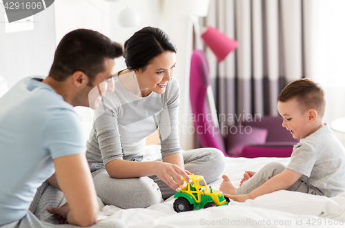 Image of happy family in bed at home or hotel room