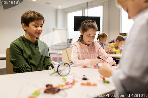 Image of happy children building robots at robotics school