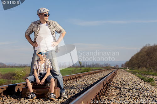 Image of Father and son walking on the railway at the day time.