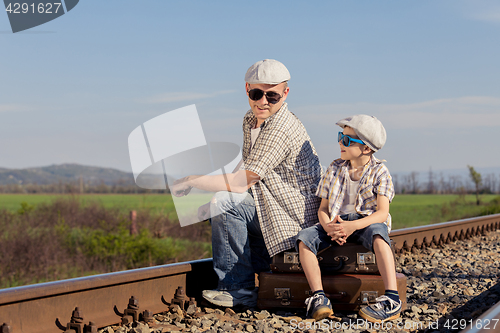 Image of Father and son walking on the railway at the day time.