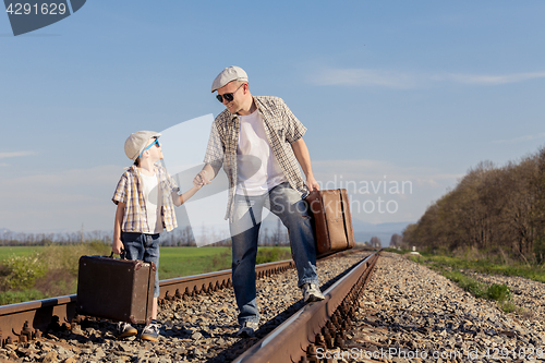 Image of Father and son walking on the railway at the day time.