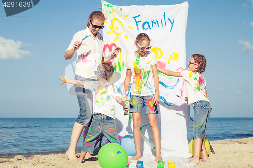 Image of Mother and children playing on the beach at the day time.