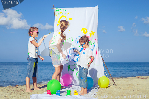 Image of Two sisters and brother playing on the beach at the day time.