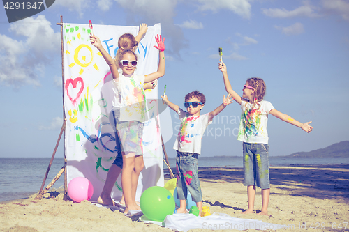 Image of Mother and children playing on the beach at the day time.
