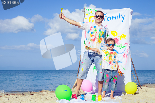 Image of Father and son playing on the beach at the day time.