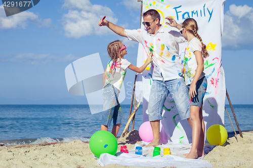 Image of Father and children playing on the beach at the day time.