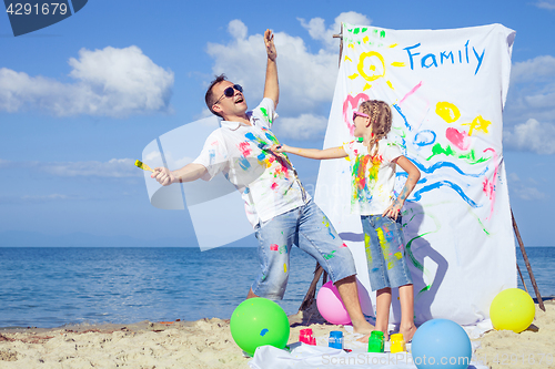 Image of Father and daughter playing on the beach at the day time.