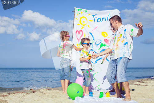 Image of Father and children playing on the beach at the day time.