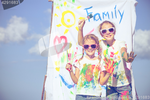 Image of Two sisters  playing on the beach at the day time.