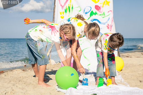 Image of Two sisters and brother playing on the beach at the day time.