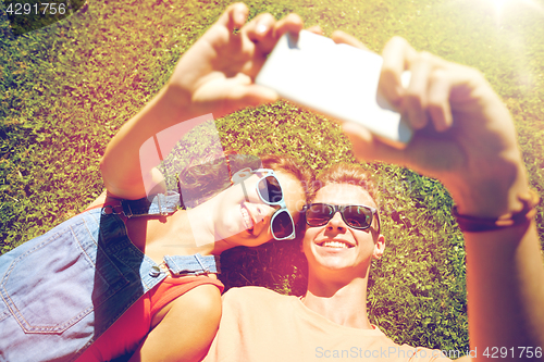 Image of happy couple taking selfie on smartphone at summer