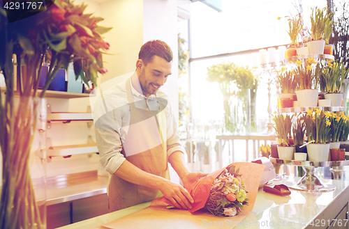 Image of florist wrapping flowers in paper at flower shop