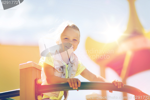 Image of happy little girl climbing on children playground