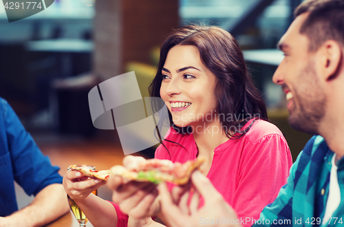 Image of friends eating pizza with beer at restaurant