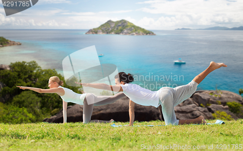 Image of happy couple making yoga exercises outdoors