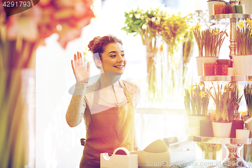 Image of smiling florist woman at flower shop cashbox