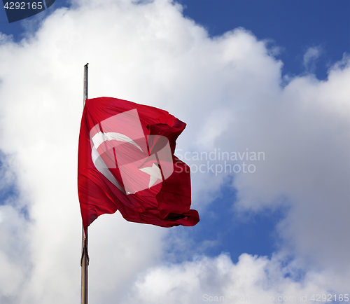 Image of Turkish flag on flagpole waving in wind