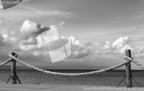 Image of Black and white view on seafront and sky with sunlight clouds in