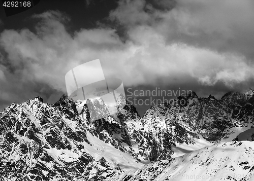 Image of Black and white view on high snowy mountains in clouds at sunny 