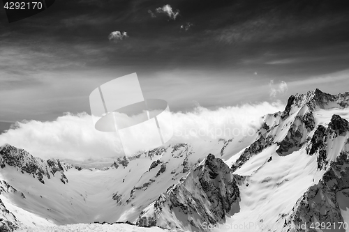 Image of Black and white view on snow sunlight mountains in clouds