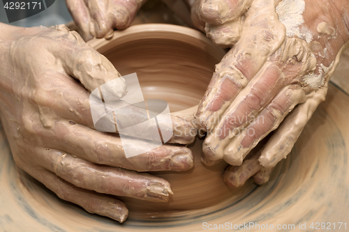 Image of Women hands in clay at process of making  crockery on pottery wh