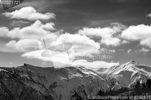 Image of Black and white view on sunlight snow mountains and sky with clo