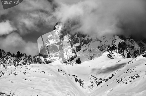 Image of Black and white view on mount Ushba in fog at sun winter day bef
