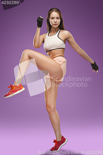 Image of Muscular young woman athlete posing at studio