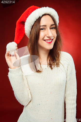Image of Surprised christmas girl wearing a santa hat