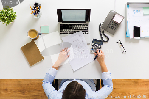 Image of businesswoman with tax report at office