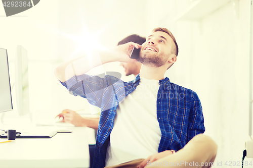 Image of happy creative man calling on cellphone at office