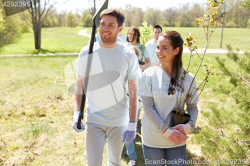 Image of group of volunteers with trees and rake in park