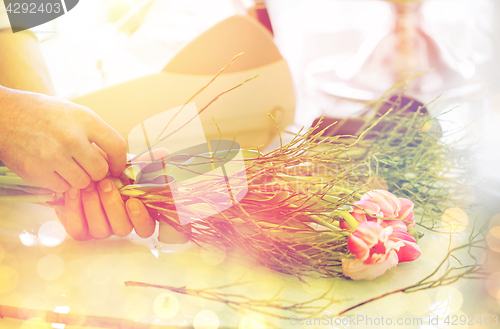 Image of close up of man making bunch at flower shop