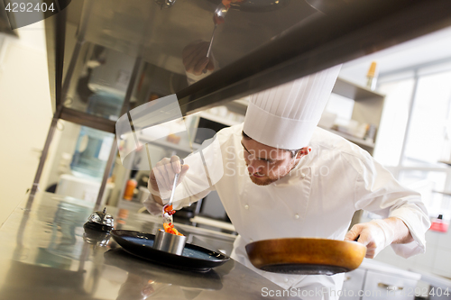 Image of happy male chef cooking food at restaurant kitchen