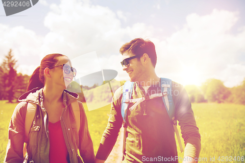 Image of happy couple with backpacks hiking outdoors