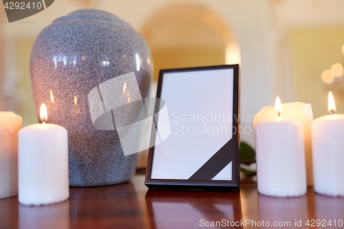 Image of photo frame, cremation urn and candles in church