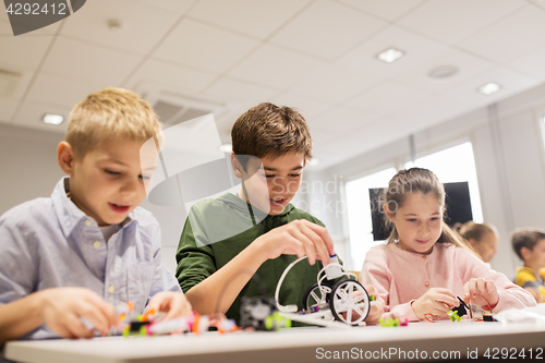 Image of happy children building robots at robotics school