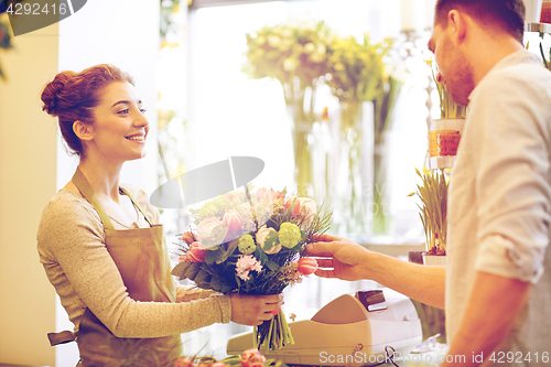 Image of smiling florist woman and man at flower shop